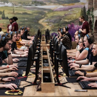 Besucher der Gamescom testen 2025 das Computerspiel "Anno 117" des deutschen Entwicklerstudios Ubisoft Blue Byte: Die Games-Branche kriselt, deutsche Studios hinken bei Top-Spielen hinterher. Finanzierung und Programmierung sind eine Herausforderung.