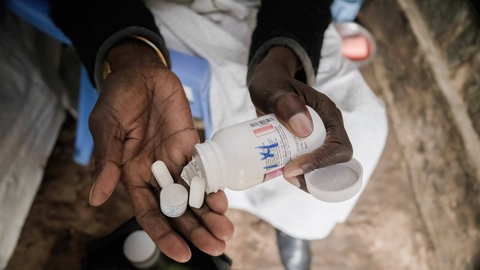 Eine Frau in Kenia nimmt ihre Medikamente: Die HIV-Therapie wird auch antiretrovirale Therapie genannt. Sie unterdrückt die Vermehrung der Viren im Körper. Die USA haben ihre Auslandshilfen drastisch gekürzt. Das hat für viele Menschen Folgen.