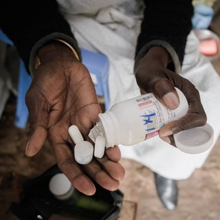 Eine Frau in Kenia nimmt ihre Medikamente: Die HIV-Therapie wird auch antiretrovirale Therapie genannt. Sie unterdrückt die Vermehrung der Viren im Körper. Die USA haben ihre Auslandshilfen drastisch gekürzt. Das hat für viele Menschen Folgen.