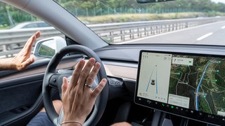 Mann fährt mit dem Tesla Model Y Auto auf der Autobahn mit Autopilot ohne Hände am Lenkrad: Automatisiertes und autonomes Fahren kann helfen, Menschen und Güter in Zukunft nachhaltiger zu transportieren. 