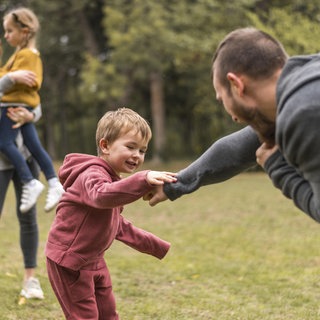 Eltern und Kinder spielen zusammen draußen