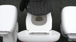 Symbolbild: Eine Frau sitzt auf einem Toilettenbecken