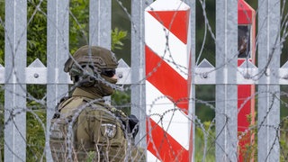 Ein Soldat der polnischen Grenzpolizei bewacht im Juli 2025 die Grenzmauer an der polnisch-belarussischen Grenze in Ozierany Małe. Jährlich versuchen zehntausende Menschen aus Afrika und dem Nahen Osten über Belarus in die EU zu gelangen. 