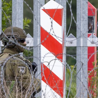 Ein Soldat der polnischen Grenzpolizei bewacht im Juli 2025 die Grenzmauer an der polnisch-belarussischen Grenze in Ozierany Małe. Jährlich versuchen zehntausende Menschen aus Afrika und dem Nahen Osten über Belarus in die EU zu gelangen. 