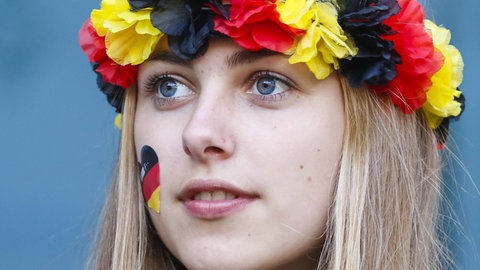 Junge Frau mit einer Blumengirlande in den deutschen Nationalfarben auf dem Kopf: Die Idee, dass es so etwas gibt wie ein "deutsches Volk" mit "deutscher Kultur", ist überraschend jung. 