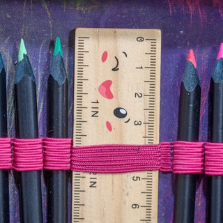 Symbolbild:  Gespitzte Buntstifte und ein Lineal stecken in einer Federmappe eines Schulkindes.