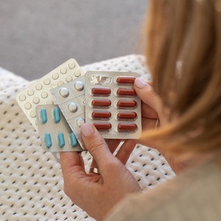 Frau hält Pillen in ihren Händen