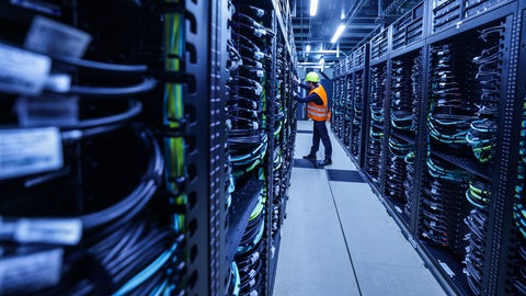 Mitarbeiter arbeitet am Supercomputers "Jupiter" im Forschungszentrum Jülich: Künstliche Intelligenz verbraucht viel Energie und Rohstoffe. Forschung zeigt: Kleine und gezielte KI-Systeme können effizient Probleme lösen.