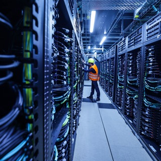 Mitarbeiter arbeitet am Supercomputers "Jupiter" im Forschungszentrum Jülich: Künstliche Intelligenz verbraucht viel Energie und Rohstoffe. Forschung zeigt: Kleine und gezielte KI-Systeme können effizient Probleme lösen.