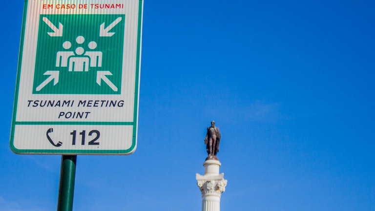 Schild in Lissabon zeigt einen Sammelpunkt und eine Notrufnummer an für den Fall eines Tsunamis: Das Erdbeben 1755 zerstörte Portugals Hauptstadt. – Katastrophen sorgen für Verwüstung, sind aber auch Anstoß für Wandel.