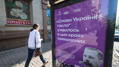 Slava Ukraini in kyrillischer Schrift: Ein Infoplakat in Charkiw zur Herkunft des Grußes "Ruhm der Ukraine", der seit dem Angiff Russlands auf die Ukraine international bekannt ist. Er soll zurückgehen auf ukrainische Studenten in der Zeit um 1900.