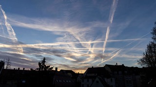 Kondensstreifen am Himmel. Diese künstlichen Wolken entstehen aus den Abgasen von Flugzeugen. Es gibt aber auch Verschwörungsmythen, die diese "Chemtrails" anders deuten.