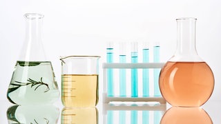 Laborgläser mit farbigen Flüssigkeiten: Warum ist Glas durchsichtig?