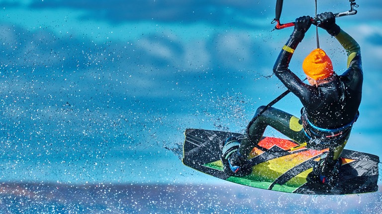 Kitesurfer beim Sprung: Adrenalin ermöglicht dem Körper Höchstleistungen, fokussiert den Geist. Es ist wahrlich lebensrettend, auch in der Medizin. Alle Tiere kennen ein solche schnelle Stressreaktion, aber wohl nur der Mensch sucht den Adrenalinkick.