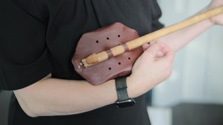 Die Ägyptologin Heidi Köpp-Junk hält eine alte Laute in den Händen. 