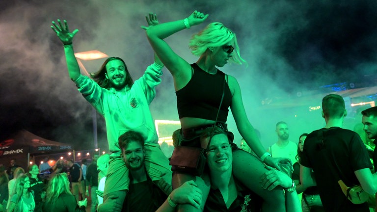 Junge Menschen tanzen beim Shelterwood Festival zu heißen Beats auf der Rheinpromenade in Emmerich: Immer weniger Menschen gehen abends in Clubs und Kneipen. Sie organisieren Raves, pilgern zu DJ-Gigs auf der grünen Wiese oder treffen sich zu Hause. 