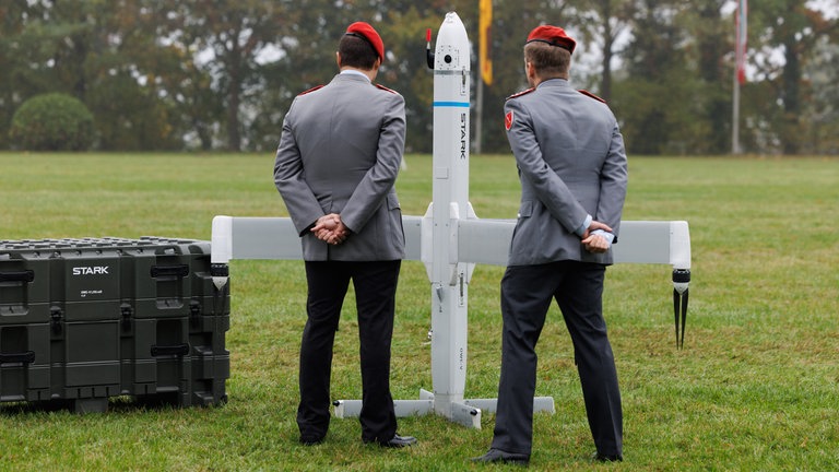 Zwei Soldaten betrachten eine Drohne der Firma Stark Defence beim Appell für das Artilleriebataillon 215 im Oktober 2025: In Deutschland sind Dutzende neue Rüstungs-Start-ups entstanden. Kritiker halten die Produkte für gefährlich.