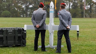 Zwei Soldaten betrachten eine Drohne der Firma Stark Defence beim Appell für das Artilleriebataillon 215 im Oktober 2025: In Deutschland sind Dutzende neue Rüstungs-Start-ups entstanden. Kritiker halten die Produkte für gefährlich.