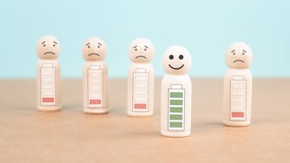 Holzfigürchen, eins mit voller grüner Batterie, vier mit leerer roter Batterie: Krankschreibungen wegen psychischer Belastung steigen seit Jahren. Arbeitgeber und Führungskräfte können aber etwas tun, um ihre Mitarbeitenden zu unterstützen.