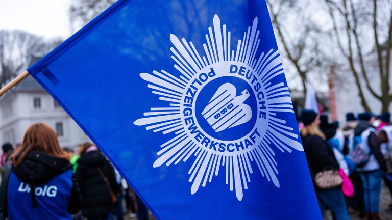 Flagge der DPolG bei einer Kundgebung am 10.2.2026 in Saarbrücken: Gewerkschaften, auch die der Polizei, setzen sich für bessere Arbeitsbedingungen ein. Vor allem die DPolG will laut Analyse des SWR Data Lab aber auch die Sicherheitspolitik beeinflussen.