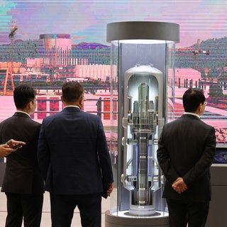 Besucher der Atomenergiemesse betrachten ein in Südkorea entwickeltes innovatives kleines modulares Reaktormodell während der diesjährigen Internationalen Atomenergieausstellung im BEXCO-Ausstellungszentrum in der südöstlichen Hafenstadt Busan am 22. April 2026.