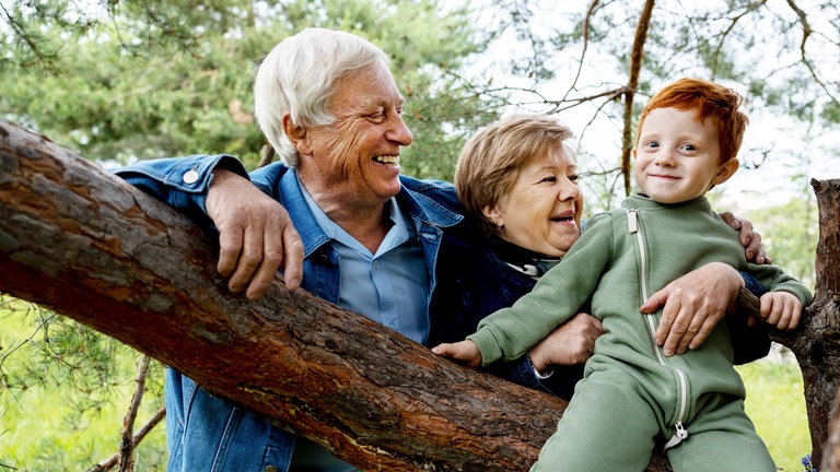 Großeltern und Enkel im Wald: Wenn Kinder und Zeit mit Oma und Opa verbringen, macht das nicht nur einfach Spaß, sondern alle profitieren – auch die Eltern.