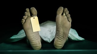Fußsohlen eines liegenden Toten, an einem Zeh hängt ein Zettel (Symbolbild): Kaum ein medizinischer Bereich ist so fehleranfällig wie die Leichenschau: Ärztinnen und Ärzte sind oft schlecht ausgebildet und übersehen immer wieder Verletzungen. 