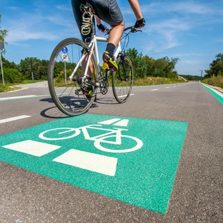 Radschnellweg in Müchen mit grüner Markierung auf dem Boden: Fahrradfahren ist gesund und klimafreundlich – im Alltag aber auch gefährlich und wenig komfortabel. Für stressfreien Fahrspaß braucht es neben sicheren Radwegen auch eine smarte Navigation und mehr Komfort, etwa bei Bahnfahrten.