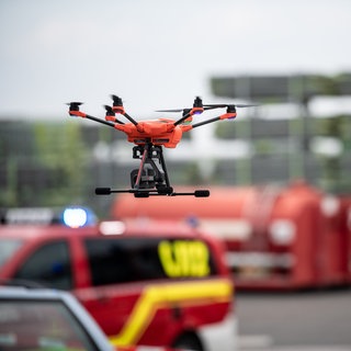 Eine Drohne fliegt vor Einsatzfahrzeugen bei einem Test-Einsatz. Das Deutsche Rettungsrobotik-Zentrum (DRZ) stellt einen neuartigen Robotikleitwagen für Katastropheneinsätze vor. 