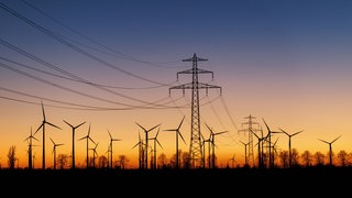 Symbolbild: Zahlreiche Windkraftanlagen und eine Stromtrasse