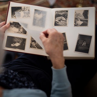 Eine Frau blättert in einem Fotoalbum