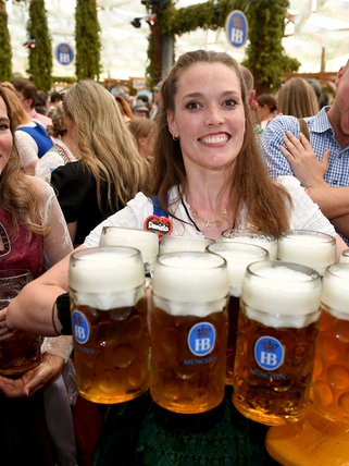 Eine Bedienung bringt im Hofbräu-Festzelt nach dem Anstich beim 190. Münchner Oktoberfest 2025 Bier zu den Gästen: Ist das jährliche Großereignis mehr als ein Massenrausch in Tracht?