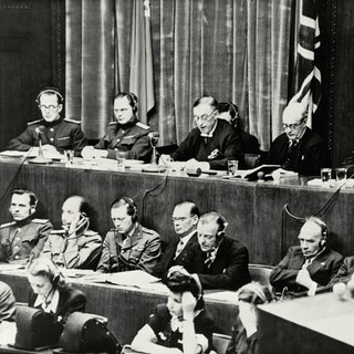 Urteilsverkündung am 1. Oktober 1946 beim Nürnberger Kriegsverbrecherprozeß vor dem alliierten Militärtribunal. Die Richterbank im Justizpalast während der Verlesung der Urteilsbegründung. V. l. n. r.: Wolchkow, Nikitschenko (UdSSR), Birkett, Lawrence (GB) und Biddle (USA)