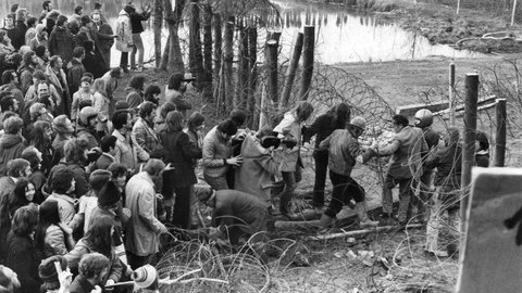 Mehrere hundert Umweltschützer und Kernkraftgegner stürmen im Anschluss an eine Kundgebung am 23. Februar 1975 das von der Polizei mit Stacheldraht umzäunte Baugelände des geplanten Atomkraftwerks bei Wyhl im Kreis Emmendingen. Mehrere Polizisten und Demonstranten wurden dabei verletzt.