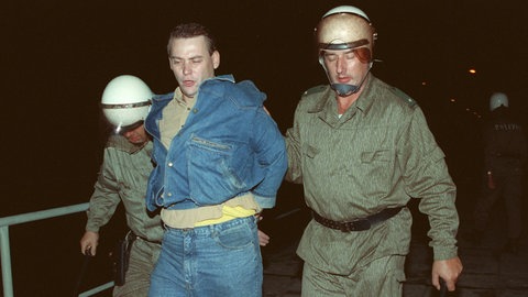 Zwei Polizisten führen einen Mann ab: Zu schweren Ãbergriffen von Rechtsradikalen auf Ausländerheime in Hoyerswerda und weiteren Orten Sachsens und anderen ostdeutschen Bundesländern kam es in den Tagen um den 22.9.1991. In Hoyerswerda, wo Rechtsextremisten die Polizei angriffen und sich mit Gegendemonstranten prügelten, wurden zahlreiche Personen festgenommen. 