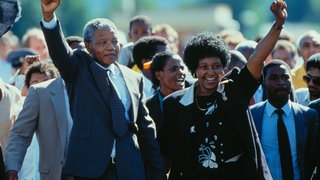 Der Anti-Apartheid-Kämpfer Nelson Mandela mit seiner Frau Winnie verlässt am 11. Februar 1990 nach 27 Jahren Haft als freier Mann das Victor-Verster-Gefängnis. Er wurde am 10. Dezember 1993, zusammen mit Frederik Willem de Klerk, mit dem Friedensnobelpreis ausgezeichnet.