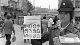 Eine Polizistin verteilt am 20.10.1977 an der Lorenzkirche in Nürnberg an die Bevölkerung Flugblätter mit der Aufschrift "Dringend gesuchte Terroristen". Die Ermordung des Arbeitsgeberpräsidenten Hanns Martin Schleyer hat die bisher größte Fahndung in der Geschichte der Bundesrepublik Deutschland ausgelöst. 