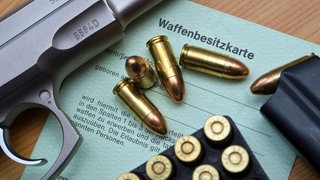 Eine Kaliber 9 mm Pistole, Patronen und ein Magazin liegen auf einer Waffenbesitzkarte. Nach dem Amoklauf von Winnenden wurde eine Verschärfung des Waffenrechts diskutiert.