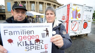 Hardy Schober und Christiane Sättler-Adel (Aktionsbündnis Amoklauf Winnenden) am 17.10.2009 in Stuttgart. Rechts ein Container, in dem Nutzer sogenannte Computer-Killerspiele entsorgen können.