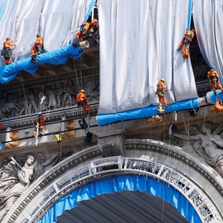 Gebäudekletterer haben mit der Verhüllung des Triumphbogens (Arc de Triomphe) begonnen. Bis zum 18. September 2021 soll die Verhüllung vollendet sein – und damit ein Lebenstraum des Künstler-Ehepaars Christo und Jeanne-Claude, dessen Erfüllung beide jedoch nicht mehr miterleben können.