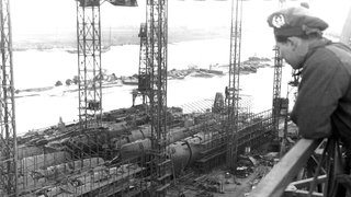 Ein schottischer Soldat blickt am 28. April 1945 in Bremen auf eine Werft für U-Boote. Am 28. April 1945 eroberte die 2. britische Armee die norddeutsche Hansestadt.