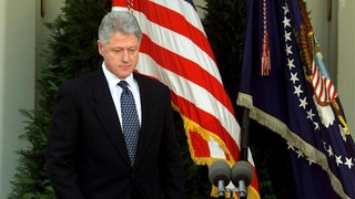 US-Präsident Bill Clinton geht auf das Podium, kurz bevor er im Rosengarten des Weißen Hauses eine Erklärung verliest, nachdem der Senat am 12. Februar 1999 in Washington, DC, dafür gestimmt hatte, ihn vom Amtsenthebungsverfahren freizusprechen. Clinton entschuldigte sich für die Handlungen, die zu seiner Amtsenthebung und dem anschließenden Freispruch durch den Senat geführt hatten, und sagte, es tue ihm "zutiefst leid".