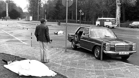 Der Tatort nach dem Mord an Generalbundesanwalt Siegfried Buback mit den zugedeckten Leichen von Buback und seines Fahrers sowie der Dienstwagen des Generalbundesanwaltes in Karlsruhe (Archivfoto vom 07.04.1977)