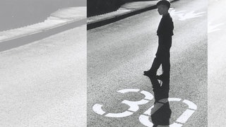 Ein Kind steht im Gegenlicht auf einer mit "30" gekennzeichneten Straße: 1983 fast eine Revolution – die Stadt Buxtehude führt in einem großflächigen Kernbereich Tempo 30 ein (Symbolbild)