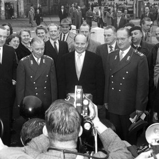 Adolf Heusinger, Bundesverteidigungsminister Theodor Blank und Alfred Speidel (v. l. n. r.) während der Feierstunde am 12. November 1955 in der Ermekeil-Kaserne Bonn im Mittelpunkt des Interesses der Fotografen. Die ersten Soldaten der neuen deutschen Streitkräfte erhielten an diesem Tag von Minister Blank ihre Ernennungsurkunden. 