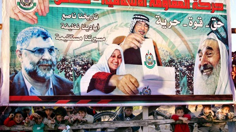 Jungs sitzen 2006 versteckt unter einem Wahlplakat der Hamas in Rafah