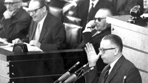 Der SPD-Abgeordnete Dr. Gustav Heinemann während der Debatte im Deutschen Bundestag in Bonn am 25.3.1958. Im Hintergrund Bundeskanzler Konrad Adenauer (mit Sonnenbrille), Außenminister Heinrich von Brentano (M) und Justizminister Fritz Schäffer. 