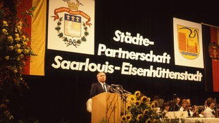 Saarlouis. Festakt anlässlich der Städteparnerschaft mit Eisenhüttenstadt (DDR) 1986, Oskar Lafontaine am Rednerpult