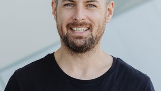 Tim Philipp vom X Lab lächelt in die Kamera