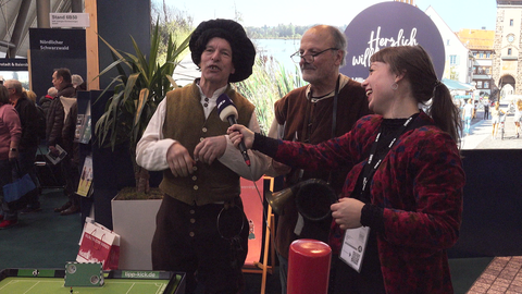 Reporterin interviewt einen Nachtwächter in historischem Kostüm
